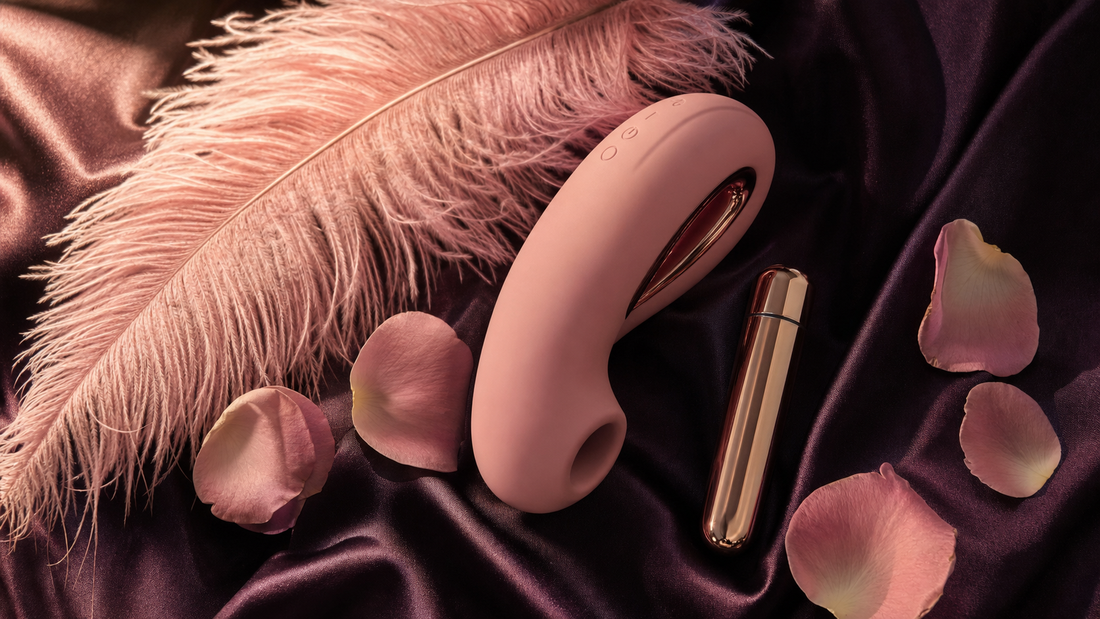 A calm, photorealistic flat-lay of beginner-friendly vibrators on aubergine silk with a single pink feather and rose petals