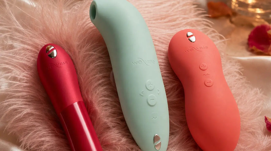 We-Vibe Melt 2, Touch X, and Tango X arranged on pink feathers and ivory satin with rose petals and candle
