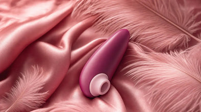 Womanizer Starlet 3 air-pulse clitoral stimulator on pink silk with ostrich feathers