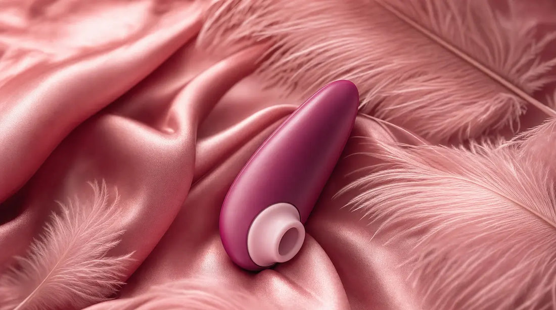 Womanizer Starlet 3 air-pulse clitoral stimulator on pink silk with ostrich feathers