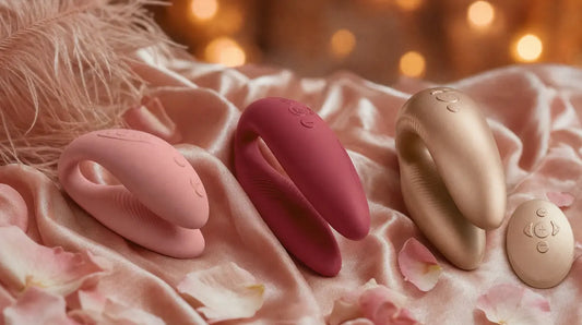 We-Vibe Sync Lite, Chorus, and Chorus Pro couples vibrators on pink silk with petals