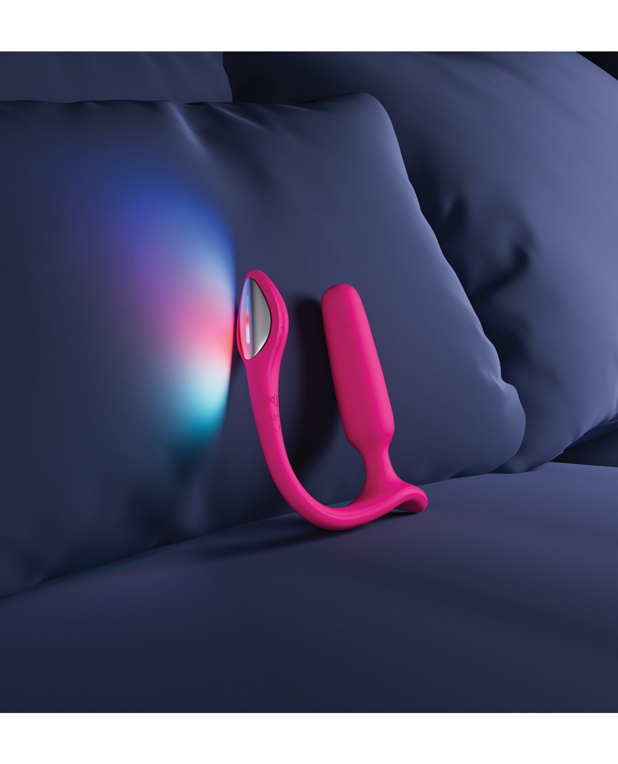 Pink and silver anal plug device on a blue pillow