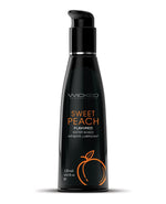 Black bottle of Wicked Sweet Peach flavored personal lubricant on a white background